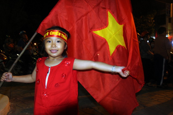 Một bé gái hào hứng cùng dòng người ăn mừng chiến thắng tại Quảng trường tỉnh Đồng Nai
