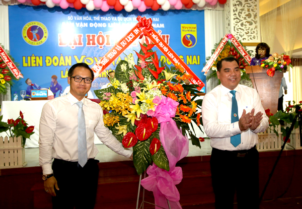 Phó giám đốc Sở Văn hóa, thể thao – du lịch Nguyễn Xuân Thanh (trái) tặng lẵng hoa chúc mừng Liên đoàn Vovinam tỉnh Đồng Nai.