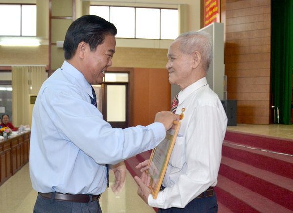 Đồng chí Thi Văn Dũng, Phó bí thư Thành ủy Biên Hòa, trao tặng huy hiệu Đảng cho đồng chí Lê Thành Bá.