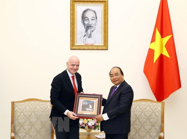 Thủ tướng Nguyễn Xuân Phúc trao tặng quà lưu niệm cho Chủ tịch Liên đoàn Bóng đá Thế giới (FIFA) Gianni Infantino. (Ảnh: Thống Nhất/TTXVN)