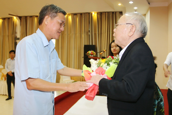 Chủ tịch UBND tỉnh Đinh Quốc Thái gửi lời chúc mừng và tặng hoa nguyên Chủ tịch UBND tỉnh Huỳnh Văn Bình, một trong hai tác giả sách “Một chút gọi là”.