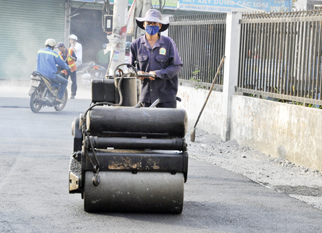Công nhân hối hả làm đường để người dân đón tết tại một con đường hẻm ở KP.5, phường Trảng Dài, TP.Biên Hòa.