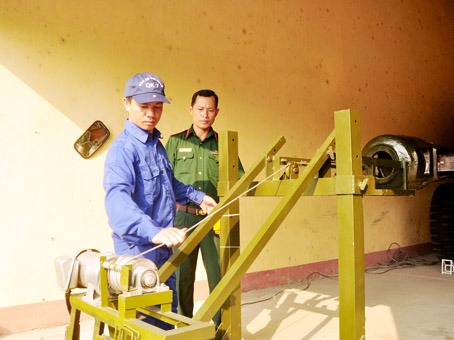 Thiếu tá Phạm Trọng Tài (phải) quan sát thiết bị ken nòng pháo mặt đất hoạt động.