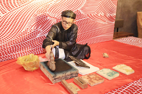 Nghệ nhân Nguyễn Đăng Tâm làm việc với các bản khắc gỗ.