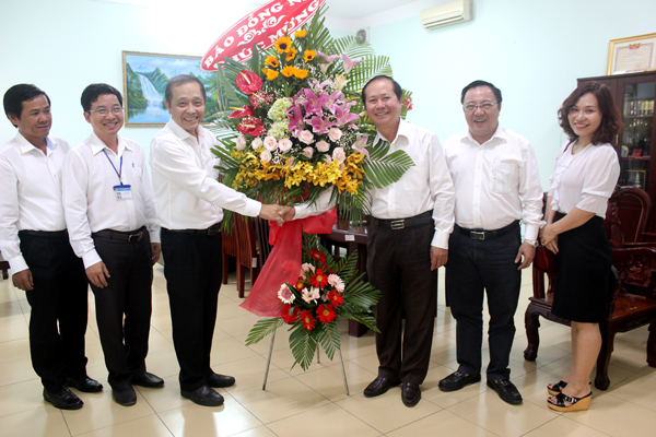 Tổng biên tập Báo Đồng Nai Trần Huy Thanh (thứ 3 từ trái qua) tặng hoa chúc mừng Giám đốc Sở Y tế Huỳnh Minh Hoàn nhân Ngày Thầy thuốc Việt Nam. Ảnh: N.THƯ