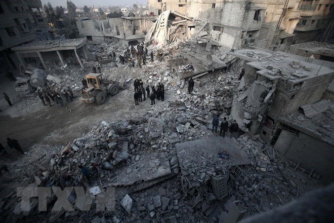 Tìm kiếm các nạn nhân sau một vụ không kích xuống Hamouria, Đông Ghouta ngày 9/1. (Nguồn: AFP/TTXVN)