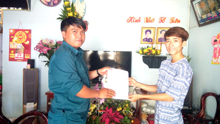 Đại diện Ban Chỉ huy quân sự xã Gia Tân 3 (trái) trao giấy gọi nhập ngũ cho anh Nguyễn Duy Tân.