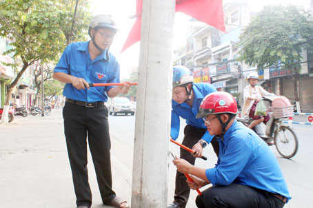 Cán bộ, đoàn viên thanh niên phường Trung Dũng (TP.Biên Hòa) ra quân xóa quảng cáo rác trên tuyến đường 30-4. 