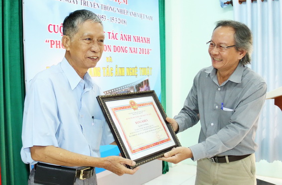 Chủ tịch Hội Văn học nghệ thuật tỉnh Nguyễn Khánh Hòa trao bằng khen của Bộ Văn hóa – thể thao và du lịch cho Nghệ sĩ nhiếp ảnh Bùi Viết Đồng.
