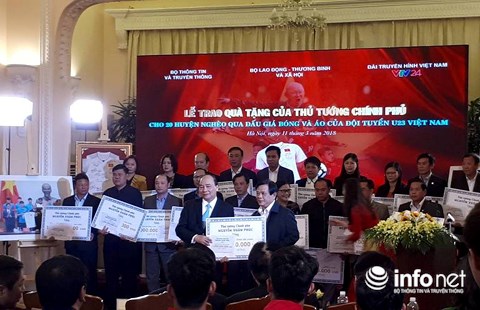 Thủ tướng Nguyễn Xuân Phúc trao số tiền đấu giá quả bóng và áo đấu của đội tuyển U23 Việt Nam cho đại diện 20 huyện nghèo thuộc 10 tỉnh.