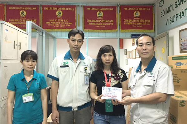 Chủ tịch Công đoàn cơ sở Công ty cổ phần Taekwang Vina Industrial Đinh Sỹ Phúc (bìa phải) trao tặng số tiền gần 66 triệu đồng do công nhân công ty đóng góp giúp đỡ gia đình của công nhân bị qua đời.
