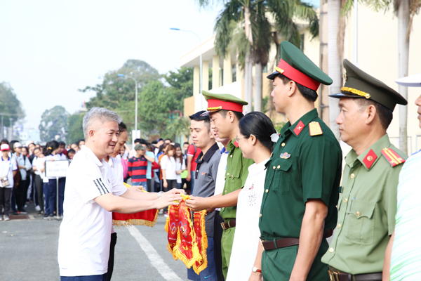 Giám đốc Sở Văn hóa, thể thao - du lịch Lê Kim Bằng trao cờ lưu niệm cho các khối vận động viên tham gia ngày chạy