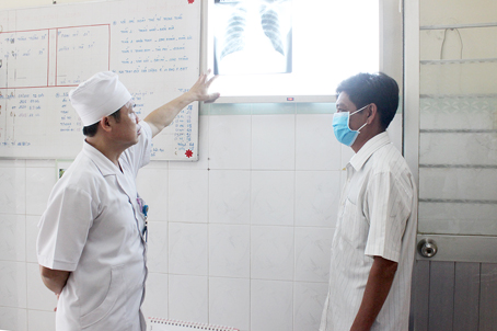 Bác sĩ Bùi Văn Thịnh, Trưởng khoa Lao B Bệnh viện phổi Đồng Nai, xem xét kết quả chụp X.quangcho một ca lao kháng thuốc đã điều trị thành công. Ảnh: A.Thư