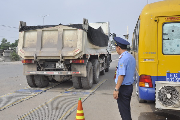 Chú thích ảnh: Lực lượng chức năng tiến hành kiểm tra tải trọng xe tại trạm kiểm soát tải trọng xe đặt trên đường Võ Nguyên Giáp (TP.Biên Hòa).