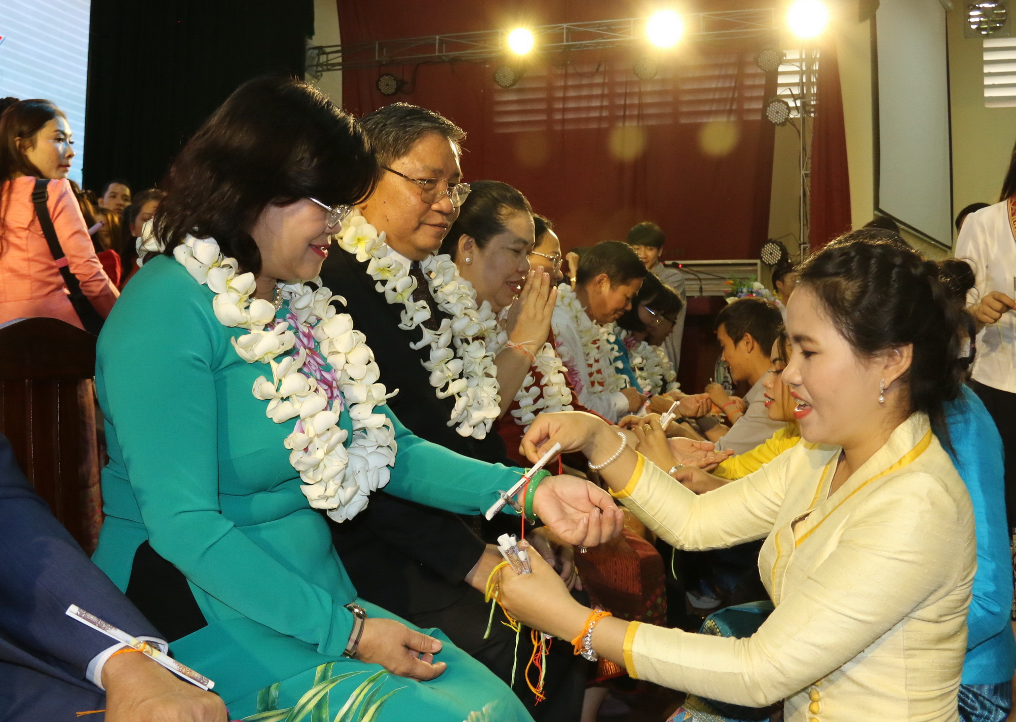 Phó chủ tịch UBND tỉnh Nguyễn Hòa Hiệp được sinh viên Lào và Campuchia thực hiện nghi thức Buộc chỉ cổ tay.