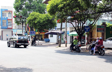  Một số người điều khiển xe máy “núp” dưới bóng râm tránh nắng khi chờ đèn đỏ tại nút giao đường Phan Trung và đường Dương Tử Giang (TP.Biên Hòa) dù vị trí này cách xa vạch dừng xe.