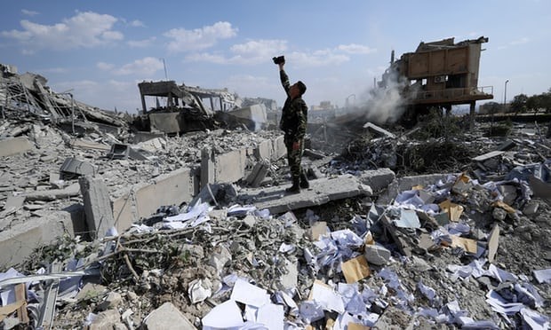 Một người lính Syria chụp ảnh tại đống đổ nát ở Trung tâm nghiên cứu khoa học gần Damascus (Nguồn: AP)