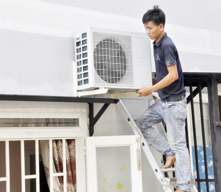 Những ngày nắng nóng, nhu cầu lắp đặt, sửa chữa và bảo dưỡng điều hòa luôn tăng cao. Trong ảnh: Một thợ điện máy lắp đặt máy lạnh cho khách hàng ở TP.Biên Hòa.