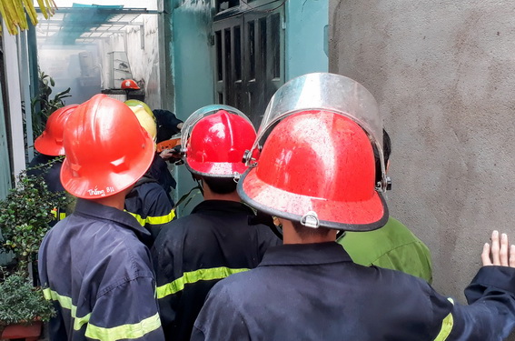 Cảnh sát Phòng cháy chữa cháy chen nhau trong hẻm chật để xịt nước vào nhà dập lửa (ảnh: CTV)