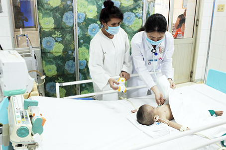 Bác sĩ Nguyễn Thị Ly Ly (phải), Trưởng khoa Tim mạch - thận niệu Bệnh viện nhi đồng Ðồng Nai, kiểm tra sức khỏe của bé Đ.B.A. sau ca mổ tim.