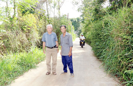 Ông Vòng Vĩnh Ốn (trái) và ông Sú Tắc Phí đi trên con đường mới của ấp.