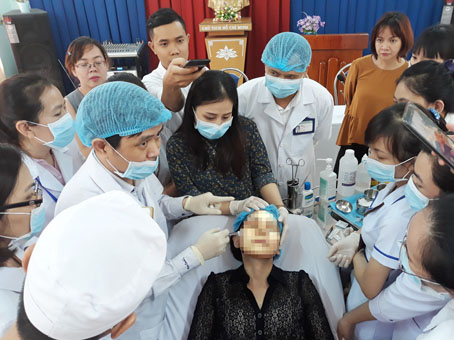 PGS-TS.Văn Thế Trung đang hướng dẫn các bác sĩ, kỹ thuật viên của Bệnh viện da liễu Đồng Nai phương pháp tiêm chất làm đầy filler trên mặt một bệnh nhân.