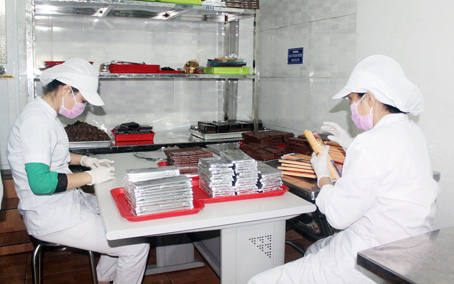 Nhân viên của Công ty TNHH ca cao Trọng Đức (xã Phú Hòa, huyện Định Quán) đóng gói sản phẩm chocolate trong phòng cách ly với đầy đủ đồ bảo hộ, đảm bảo vệ sinh an toàn thực phẩm. Ảnh: H.DUNG