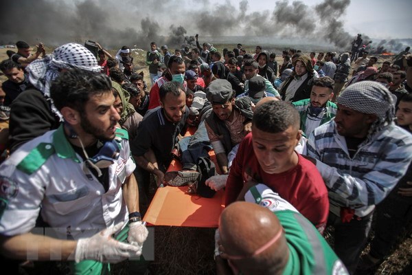 Chuyển người biểu tình Palestine bị thương trong cuộc xung đột với binh sỹ Israel dọc khu vực biên giới phía Đông Dải Gaza và Israel hôm 6/4. (Nguồn: THX/TTXVN)
