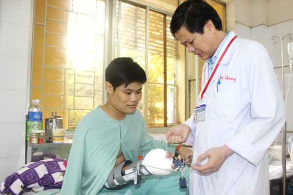 Bác sĩ CKII Nguyễn Tường Quang đang hướng dẫn bệnh nhân T tập vật lý trị liệu.