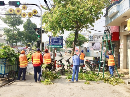 Nhân viên Trung tâm cụm công nghiệp và dịch vụ công ích TP.Biên Hòa chặt tỉa nhánh cây xanhtrên đường Hà Huy Giáp phòng tránh cây xanh ngã đổ mùa mưa bão. Ảnh: P.LIỄU