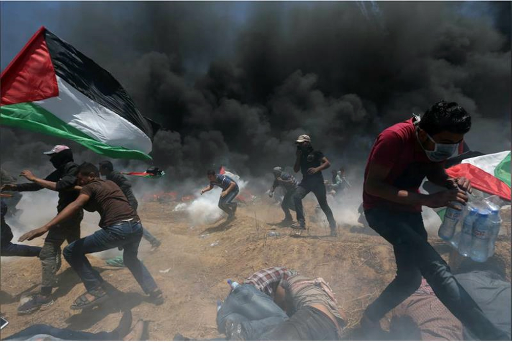 Người Palestine oằn mình trong đạn khói của binh sĩ Israel trong cuộc biểu tình tại biên giới Dải Gaza-Israel ngày 14-5 - Nguồn: REUTERS