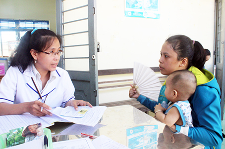 Nhân viên Trạm Y tế Gia Tân 1 (huyện Thống Nhất) làm thủ tục cho trẻ tiêm ngừa vaccine 