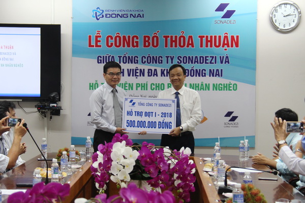 Ông Phan Đình Thám, Tổng giám đốc Tổng công ty Sonadezi (trái) trao biểu trưng 500 triệu đồng hỗ trợ các bệnh nhân nghèo (đợt 1) cho đại diện bệnh viện đa khoa Đồng Nai.