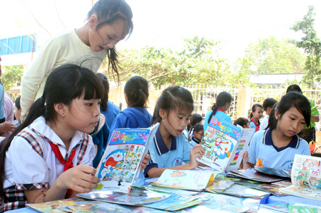 Các em thiếu nhi huyện Vĩnh Cửu đọc sách trong chương trình ngày hội tuổi thơ.