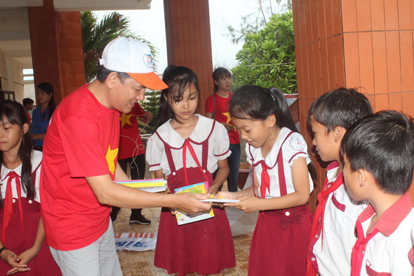 Đồng chí Phạm Tấn Linh, Phó trưởng ban Tuyên giáo Tỉnh ủy tặng tập viết cho các em học sinh