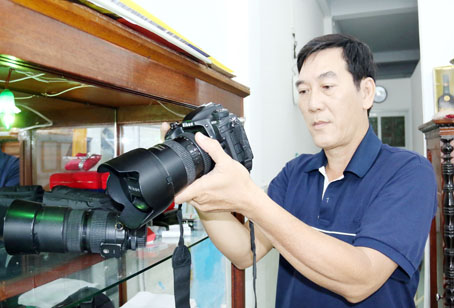 Nghệ sĩ nhiếp ảnh Trần Hữu Cường chuẩn bị máy trước giờ thực hiện chuyến đi săn ảnh. Ảnh: V.Tuyên