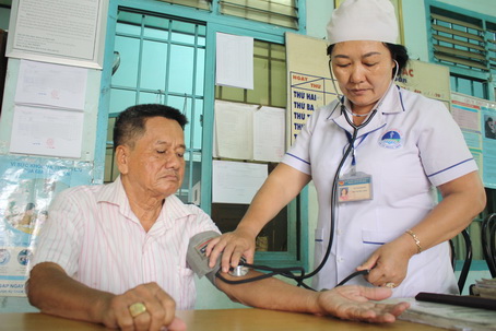 Nữ y tá Huỳnh Kim Huê khám bệnh cho ông Bùi Quang Huy (81 tuổi, ngụ ấp Bình Phước, xã Tân Bình, huyện Vĩnh Cửu).