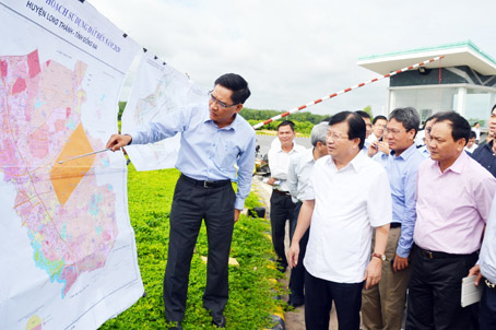Phó thủ tướng Trịnh Đình Dũng (áo trắng, giữa) xem bản đồ quy hoạch khu tái định cư cho Cảng hàng không quốc tế Long Thành tại hiện trường. Ảnh: K.Giới