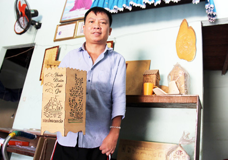 Ông Hoàng Văn Tuyến (ngụ xã Phú Lâm, huyện Tân Phú) giới thiệu sản phẩm đèn ngủ gỗ khắc laser của Xưởng thủ công mỹ nghệ Trái tim hồng.