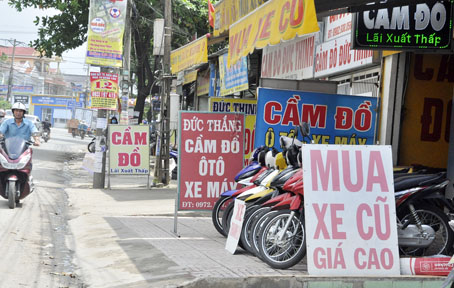 Cửa hàng mua bán xe máy cũ trên đường Bùi Văn Hòa (phường Long Bình, TP.Biên Hòa) sẵn sàng mua xe cũ với giá cao. Cạnh đó là rất nhiều tiệm cầm đồ hoạt động nhộn nhịp vào mùa World Cup 2018.