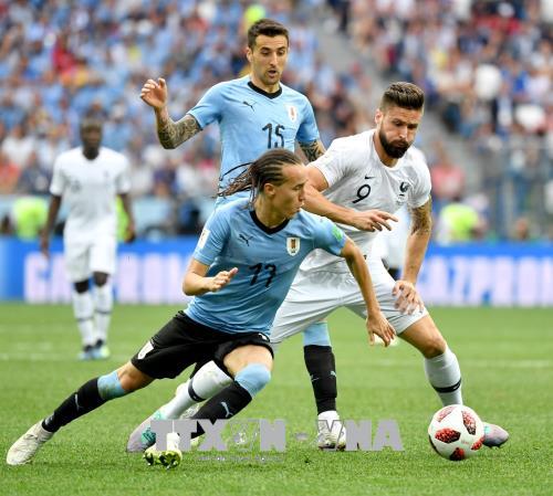 Pha tranh bóng quyết liệt giữa cầu thủ Diego Laxalt (phía trước) của Uruguay và Olivier Giroud (phải) của Pháp trong trận đấu. Ảnh: THX/ TTXVN