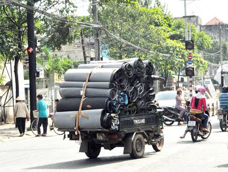 Xe ba gác chở tôn cuộn lưu thông trên đường Nguyễn Ái Quốc, đoạn qua phường Hố Nai (TP.Biên Hòa).