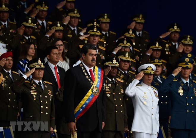 Ngày 4-8, một vụ nổ đã làm gián đoạn Lễ kỷ niệm 81 năm ngày thành lập Lực lượng Phòng vệ quốc gia Venezuela ở thủ đô Caracas. Vụ nổ xảy ra khi Tổng thống Venezuela Nicolas Maduro (giữa) đang phát biểu. (Ảnh: AFP/TTXVN)