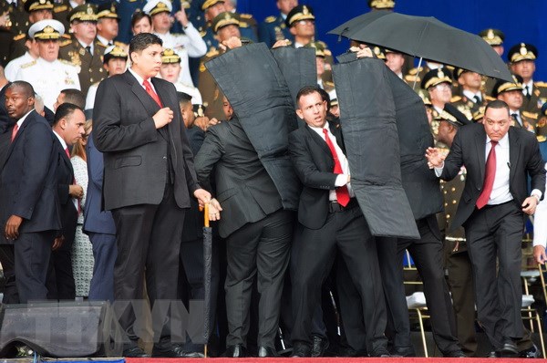 Lực lương an ninh Venezuela bảo vệ Tổng thống và các quan chức Chính phủ sơ tán khỏi hiện trường vụ nổ. (Nguồn: THX/TTXVN)