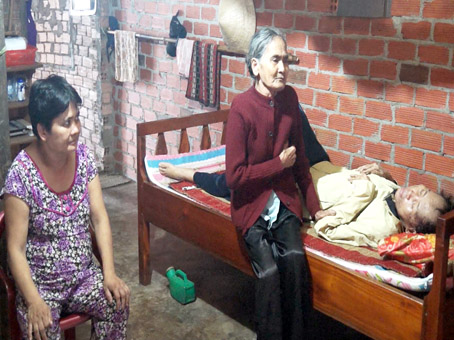 Bà Phạm Thị Đương chăm sóc con trai nằm liệt giường 10 năm nay, bên cạnh là con gái bị tâm thần.