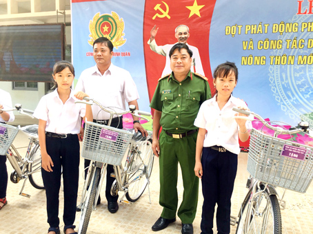 Đại diện Công an huyện Định Quán trao xe đạp cho học sinh nghèo.