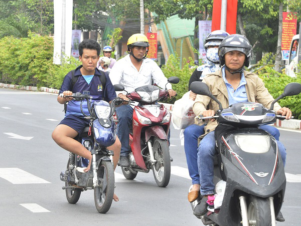 Học sinh không đội mũ bảo hiểm, chạy song song với những phương tiện khác trên đường Nguyễn Ái Quốc (TP.Biên Hòa), nếu xảy ra tai nạn sẽ rất nguy hiểm.