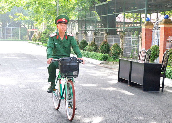 Hạ sĩ Hồ Tấn Lợi miệt mài những vòng xe đạp trên đường giao công văn hằng ngày.