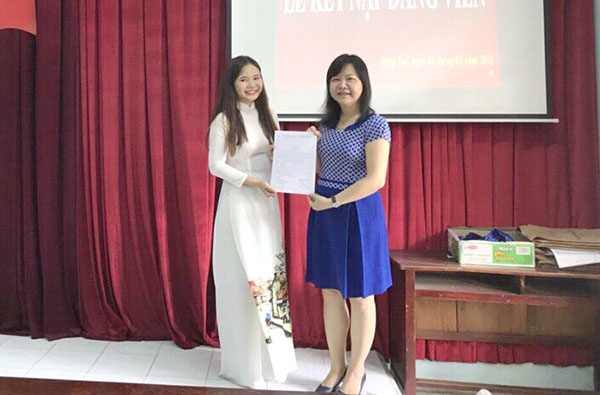 Sinh viên Trịnh Phạm Phương Thanh (bên trái), Khoa Ngoại ngữ khóa 5 Trường đại học Đồng Nai nhận quyết định kết nạp Đảng vào tháng 3 vừa qua.