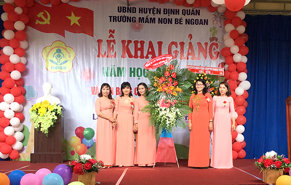 Bà Nguyễn Thị Diễm Châu, Phó chủ tịch UBND huyện trao bằng quyết định và tạng hoa chúc mừng.